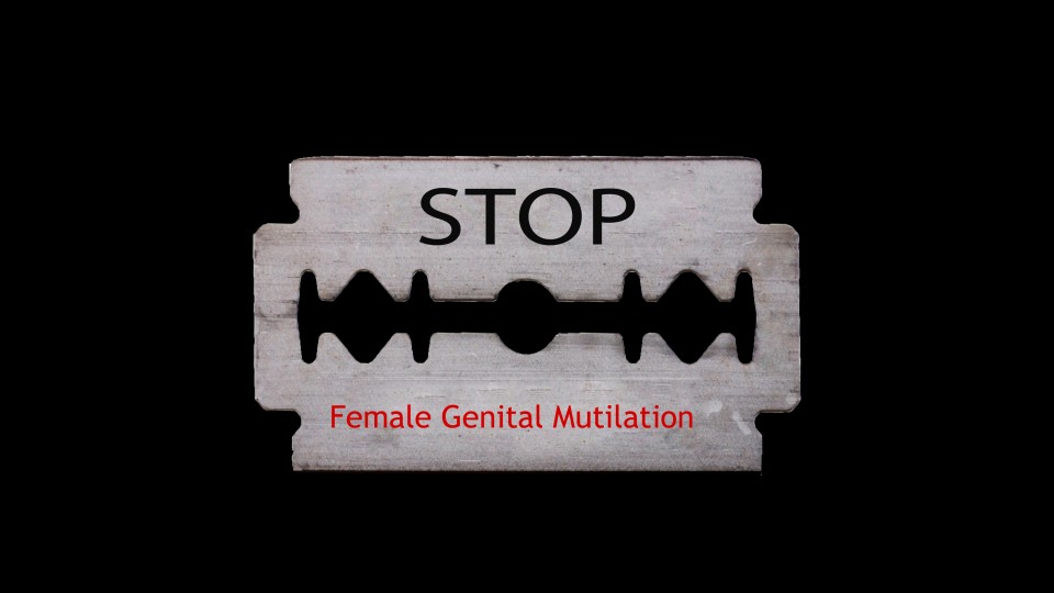 Eine Rasierklinge ist auf liegt auf einem schwarzen Hintergrund. Auf der Klinge steht auf englisch "Stoppt weibliche Genitalverstümmelung".