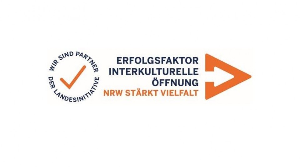 Zu sehen ist das Logo des Partnernetzwerkes. Links in einem Kreis steht: Wir sind Partner der Landesinitiative. In der Mitta steht: Erfolgsfaktor interkulturelle Öffnung, NRW stärkt Vielfalt. Ganz rechts ist eine orangene Pfeilspitze, die nach rechts zeigt.
