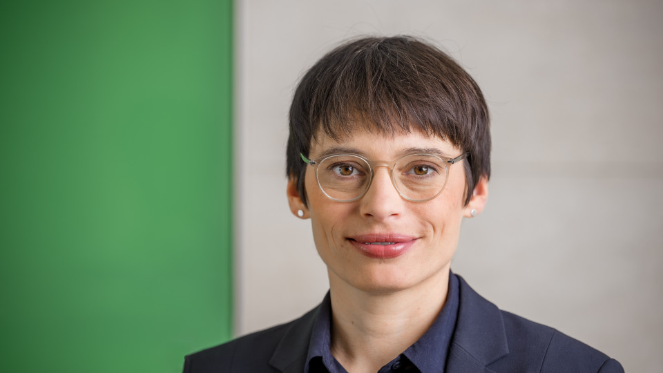 Frau Paul lächelt und schaut in die Kamera.