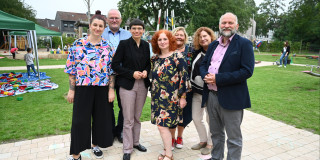 Ministerin Josefine Paul steht mit den Mitarbeitenden der städtischen KiTa Benediktstraße 46 in Duisburg und Verantwortlichen der Stadt Duisburg zusammen für ein Foto.