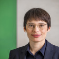 Frau Paul lächelt und schaut in die Kamera.